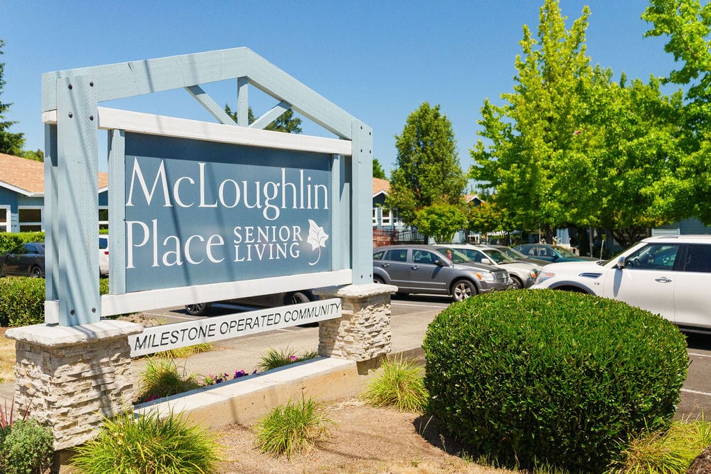 Monument sign at the street reading McLoughlin Place Senior Living, a Milestone Operated Community